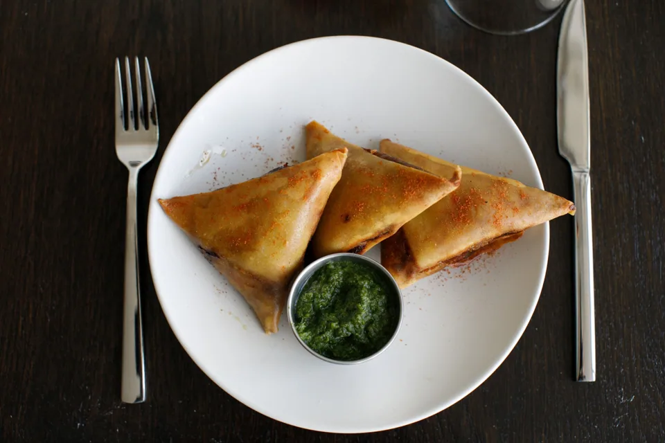 Lamb sambusa with a bowl of basbaas sauce