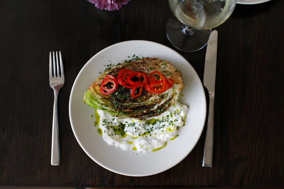 Charred cabbage with herb labneh and fresh garnish