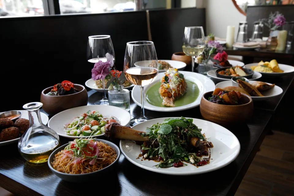 A spread of dishes and wine on a restaurant table